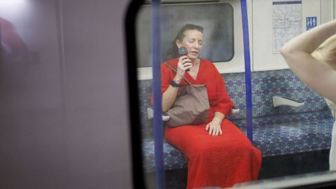Una persona usa un ventilador el�ctrico para refrescarse en el metro de Londres (Reino Unido).