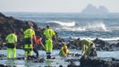 Miembros de los servicios de rescate recuperan el cuerpo de un inmigrante muerto al volcar la patera en la que viajaba cerca de Lanzarote