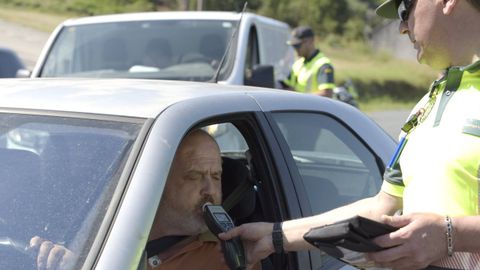 Un conductor realizando la prueba de aire espirado en un control de trfico.