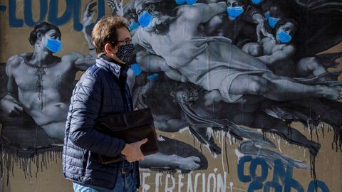 Un hombre pasa ante un mural de Sentydo en Siero