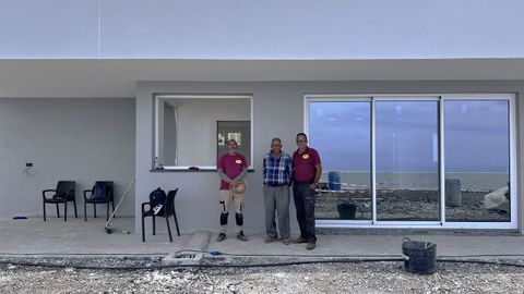 Felipe Carballo Pérez, en el centro, junto a sus dos hijos, Felipe «Pipe» Carballo Gómez, y Ricardo, junto a la casa en obras.