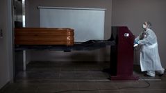 Una operaria transporta un ata�d con un fallecido por coronavirus para proceder a su incineraci�n en el interior de la capilla del crematorio-tanatorio As Burgas, en Ourense