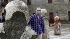 El escultor Francisco Pazos posa en la plaza de Fefins con una de sus piezas