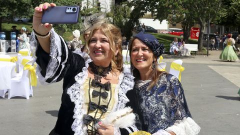 Dos mujeres vestidas de la ilustraci�n se sacan un �selfie�.