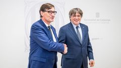 El presidente de la Generalitat, Salvador Illa, saluda al presidente de Junts, Carles Puigdemont, durante una reunin en Bruselas.