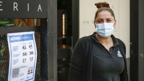 Tania Fern�ndez, del Cuatro Lunas de O Couto, ante el cartel del c�digo QR del local