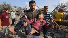 Un hombre lleva en brazos a un�ni�o salvado de los escombros de un edificio destruido por un ataque israel� a Gaza.