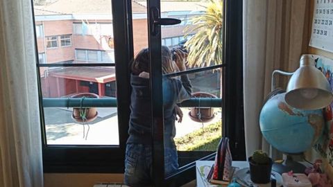 Una ni�a observa p�jaros desde la ventana de su habitaci�n