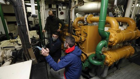 Tcnicos de una empresa externa revisando una parte del motor principal, trabajo clave para zarpar que coincidi durante la visita al palangrero de fondo