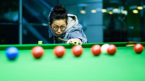Una jugadora de billar, a punto de golpear la bola durante una prueba disputada en Hong Kong
