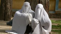 Dos mujeres vestidas con burka esperan en la calle para ser atendidas en un hospital en Afganist�n.