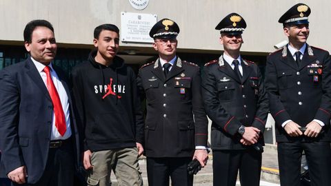 Ramy, de 13 a�os, posa con su padre y con agentes que intervinieron durante el suceso, ocurrido a las afueras de Mil�n