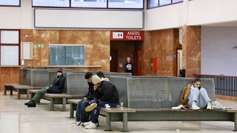 J�venes esperando en el vest�bulo de la estaci�n de buses de la calle Caballeros