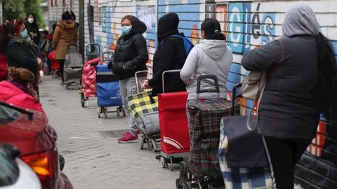 Personas hacen cola para recoger alimentos