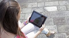 Una mujer lee La Voz de Galicia en una tableta digital.