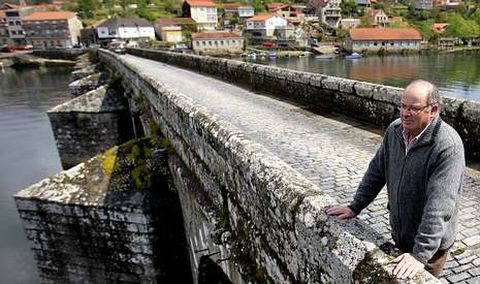 Antonio Alvarez Freijanes camina por el puente rom�nico de Pontesampaio que comunica con Arcade.