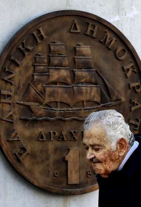 Un hombre, frente al monumento al dracma en Atenas.