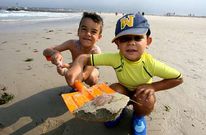 Unos ni�os muestran con su pala un ejemplar de medusa en la playa de A Rapadoira.