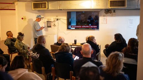Residentes de Haifa miran las noticias en un televisor, mientras permanecen refugiados en un b�nker.