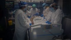 Trabajadores sanitarios  atienden a un paciente en la Unidad de Cuidados Intensivos del Hospital del Mar, en Barcelona