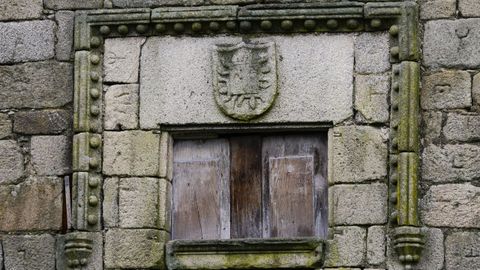 Detalle del Pazo de A Mezquita, con un alfiz sobre una ventana y las marcas de canteros en las piedras de la fachada.