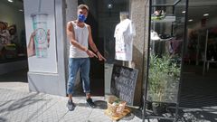 V�ctor Riob�, director de la carrera San Silvestre y due�o de Miler Vintage Running Club, junto al cartel anunciando la campa�a de recogida de alimentos