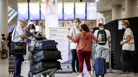 Viajeros esperando para hacerse la prueba del coronavirus en el aeropuerto de Schiphol, en Amsterdam, Países Bajos
