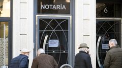 Viandantes delante de una notar�a en Lal�n