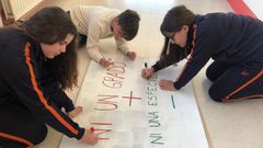 Carla, Aaron y Cintia preparan los carteles para la protesta. m. Leir�s