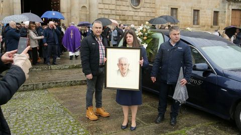 Una mujer con el retrato de �ngel Vega en la salida del f�retro de la iglesia de la Compa��a tras el funeral