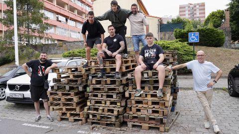 Vecinos del barrio de las Flores, en uno de los montones de palés que les suministran empresas para alimentar la gran hoguera que se instala cada año en la plaza de los Álamos