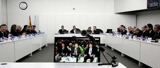 Imagen parcial de la sala de vistas del juicio del �Prestige�. En la pantalla, los tres acusados. Al fondo, el tribunal.