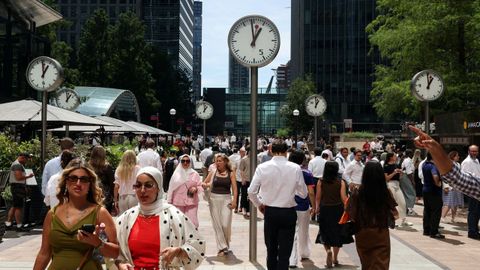 Varias personas caminan a la hora del almuerzo por el distrito financiero de Canary Wharf.