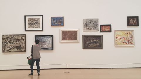 Una visitante contempla varios cuadros de Mara Helena Vieira da Silva pertenecientes a su primera etapa parisina, antes de emigrar a Brasil. En este perodo predominan los tableros y jugadores de ajedrez, metfora de la existencia misma.