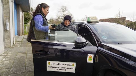 La taxista M&oacute;nica Dap&iacute;a ayuda a subir al taxi a Ramona &Aacute;lvarez, vecina de 93 a&ntilde;os