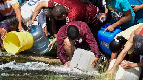 Vecinos de Caracas recogen agua del río Guaire ante los problemas de desabastecimiento