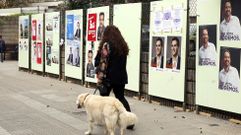 Una mujer pasa por delante de carteles electorales de los distintos candidatos a Presidente de Gobierno para las elecciones generales del prximo domingo. 