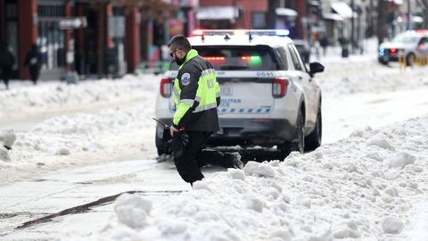 Un polic�a camina por una calle cubierta de nieve en el centro de Washington.