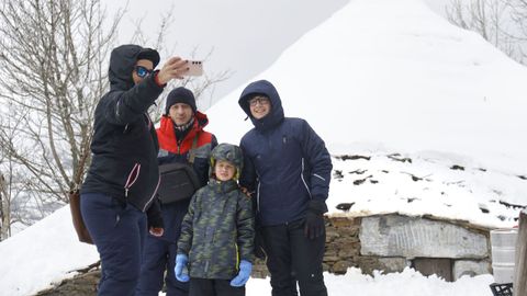 Una familia se hace un retrato junto a las pallozas