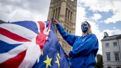 Una manifestante en contra del �brexit� sostiene las banderas de Reino Unido y de la UE en el centro de Londres.