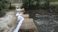 Trabajos este jueves en el Leng�elle, poco antes de A Pontraga (Ordes): aspiraci�n del pur�n retenido por la barrera anticontaminaci�n y toma de muestras del agua