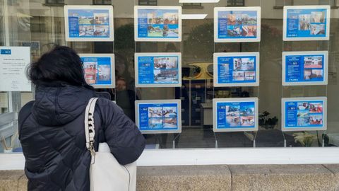Una compostelana ojea los precios de varias viviendas ubicadas en la ciudad
