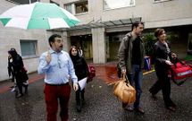 Luis Amador, con paraguas, acompa�a a los coches a los equipos que salen de visita.