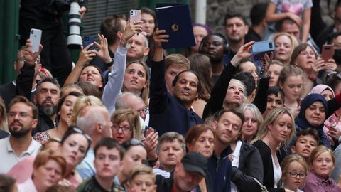 Personas intentando captar el paso del cortejo fnebre por Edimburgo