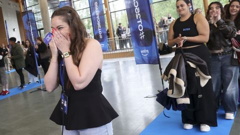 Momento en el que Noemí Galera le comunica a Cristina que pasa a la segunda fase del «casting» de «Operación Triunfo». Mientras, sus compañeros aplauden en la cola.