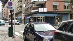 Coches estacionados en la zona azul de Oviedo, junto a un parquímetro