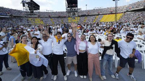 Varias personas esperan a que empiece una vigilia de 40.000 personas del papa Le�n XIV en el Estadio Ol�mpico de Barcelona.