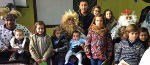 Varios ni�os de Coir�s posan con sus majestades en el local social de Queir�s.