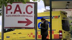 Una mujer con mascarilla frente a la entrada de urgencias del hospital de Monforte