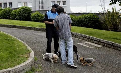 Un agente multando a un vecino por llevar sus perros sin bozal, en una imagen de archivo.